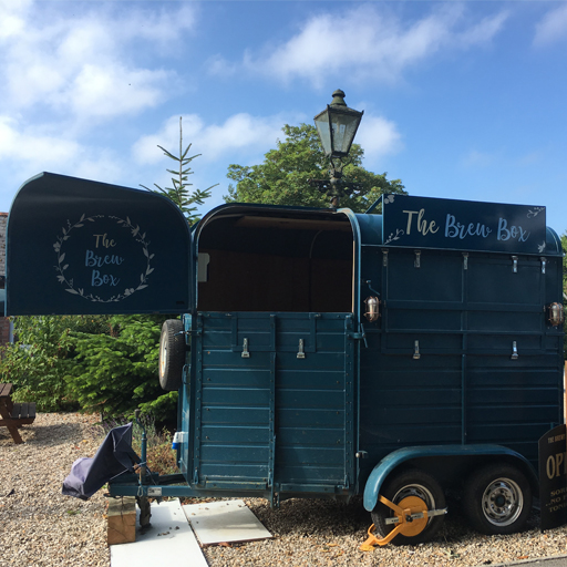The Brew Box mobile bar in the pub garden with a cloudy blue sky