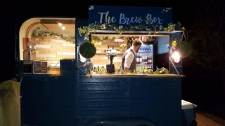 The Brew Box at night with a busy barman inside